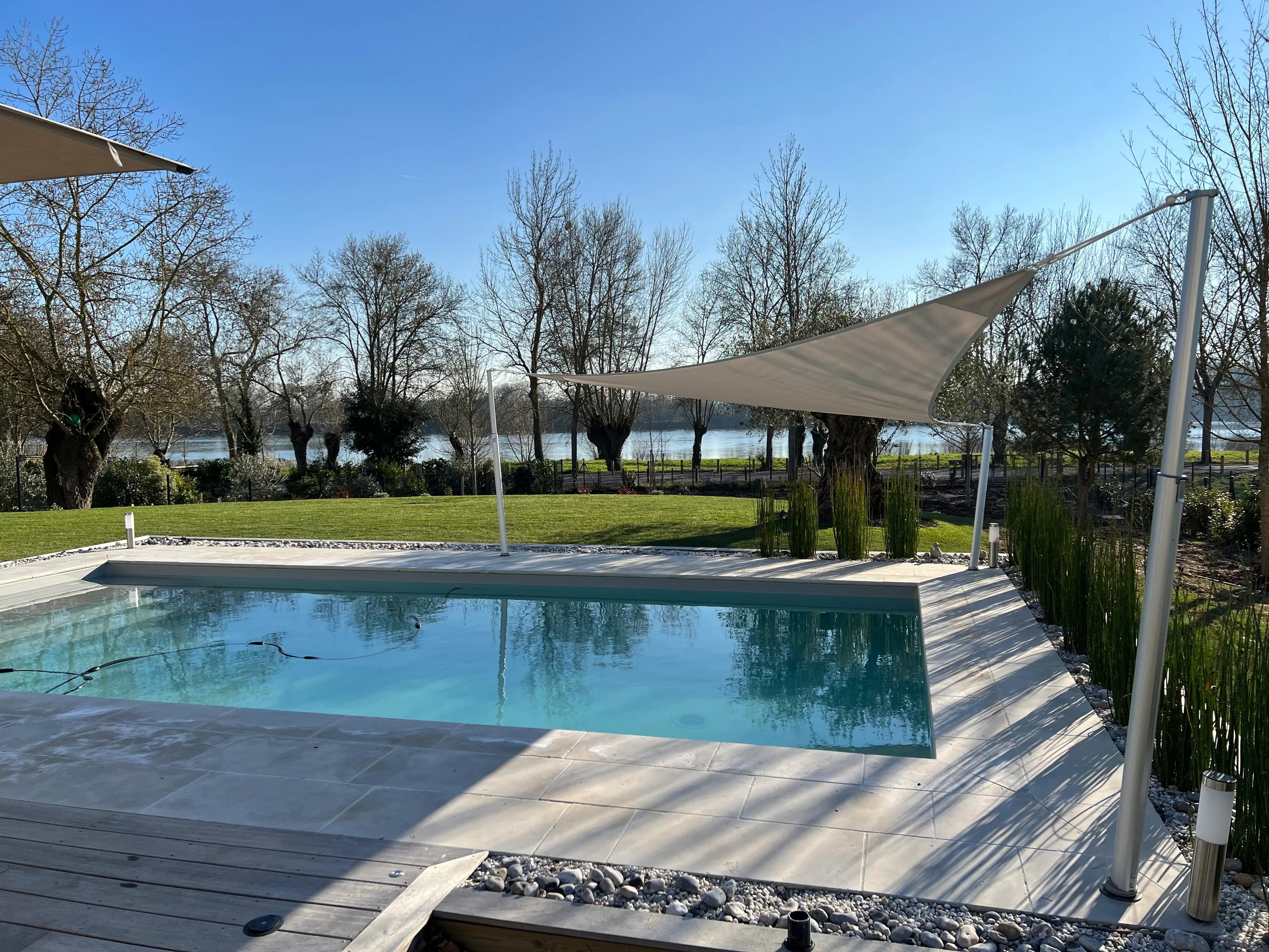 Dreieckiges Sonnensegel zur Poolbeschattung mit teleskopischen Sonnensegelmasten