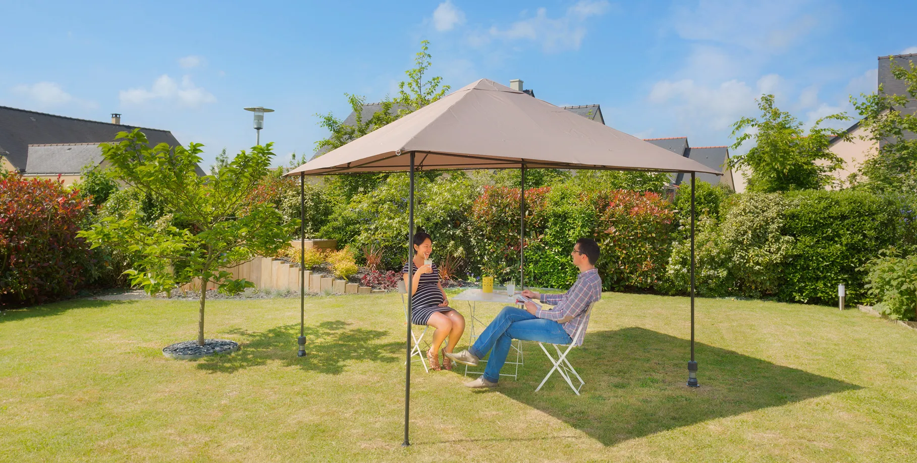 pavillon mit zwei Gard&Rock pfosten installiert, in bodenanker eingeklickt, paar sitzt im schatten im garten