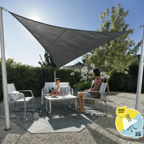 Sonnensegel auf Terrasse installiert, schafft einen schattigen und stilvollen Bereich für Mahlzeiten im Freien.